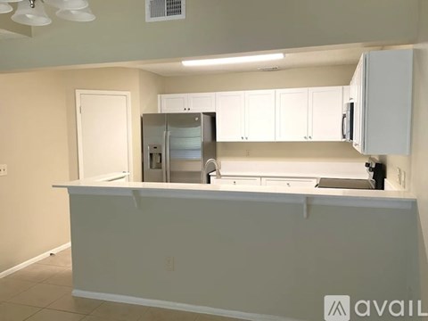 A kitchen with white cabinets and a countertop.