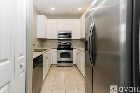 A modern kitchen with stainless steel appliances and white cabinets.