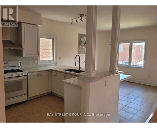 A kitchen with white cabinets and a tiled floor.