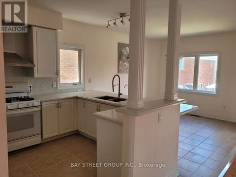 A kitchen with white cabinets and a tiled floor.