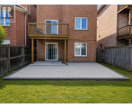 A brick building with a balcony and a patio in front.