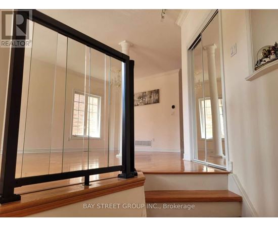 A glass door with a black frame is in the foreground of a white room.