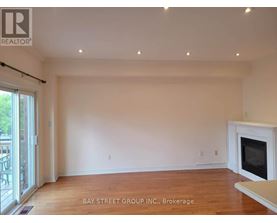 A spacious living room with a fireplace and hardwood floors.
