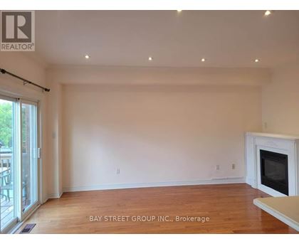 A spacious living room with a fireplace and hardwood floors.