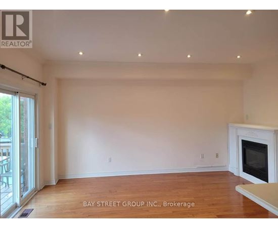 A spacious living room with a fireplace and hardwood floors.