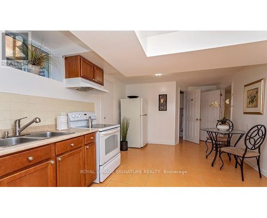 A kitchen with wooden cabinets and a white fridge.