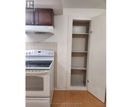 A white oven in a kitchen with a white cabinet and a white door.
