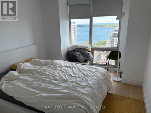A bedroom with a large bed and a view of the water.