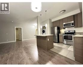 A modern kitchen with a wooden floor and stainless steel appliances.