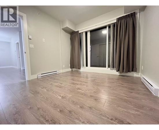 A room with wooden flooring and a sliding glass door.