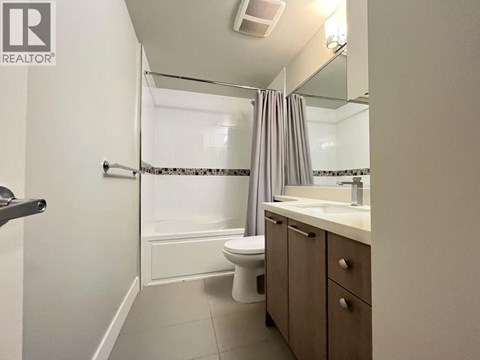 A bathroom with a toilet, sink, and shower.