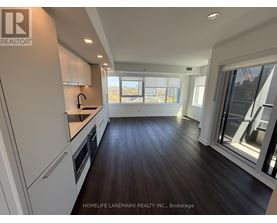 A modern kitchen with dark wood floors and white cabinets.