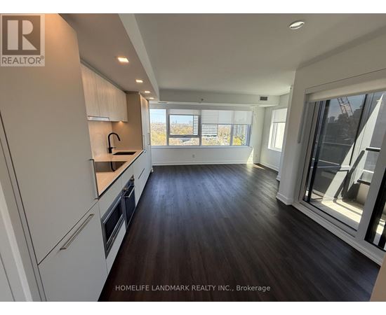A modern kitchen with dark wood floors and white cabinets.