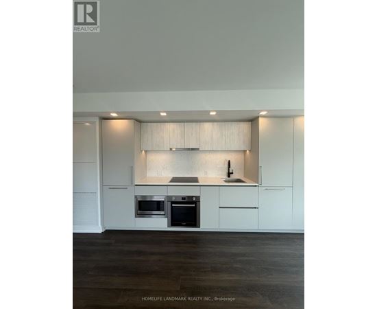 A modern kitchen with white cabinets and stainless steel appliances.