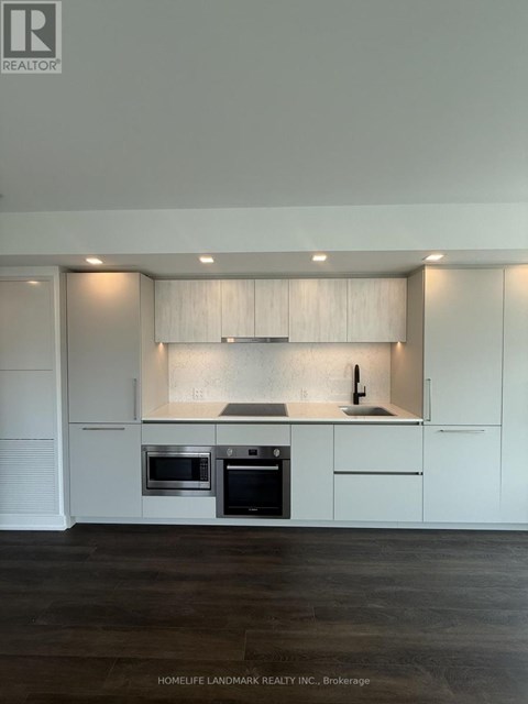 A modern kitchen with white cabinets and stainless steel appliances.