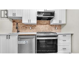 A kitchen with white cabinets and a brick wall.