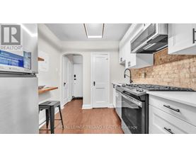 A kitchen with a stove top oven and a refrigerator.