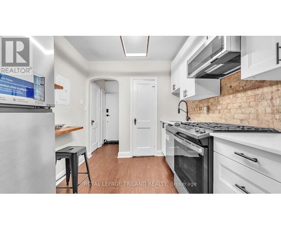 A kitchen with a stove top oven and a refrigerator.