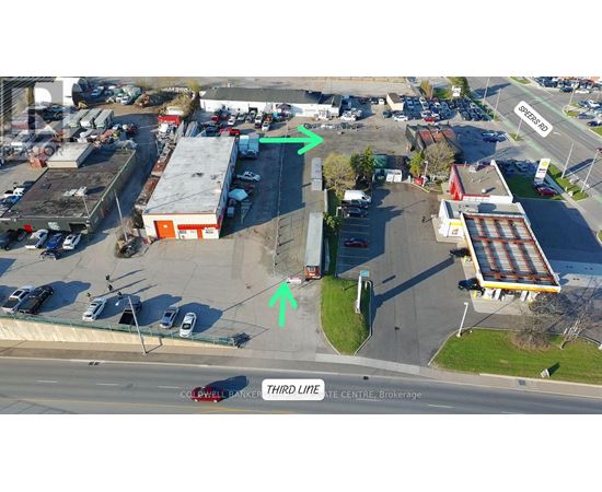 An aerial view of a parking lot with a green arrow pointing to a building and a red arrow pointing to a tree.