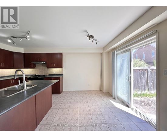 A kitchen with brown cabinets and a stainless steel sink.