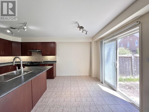 A kitchen with brown cabinets and a stainless steel sink.