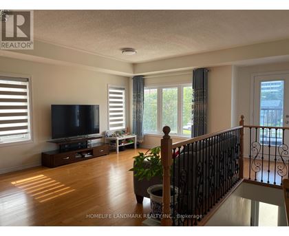 A living room with a television, a plant, and a staircase.