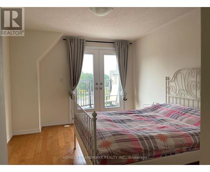 A bedroom with a bed, dresser, and window with curtains.