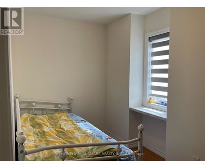 A bedroom with a bed and a window with blinds.