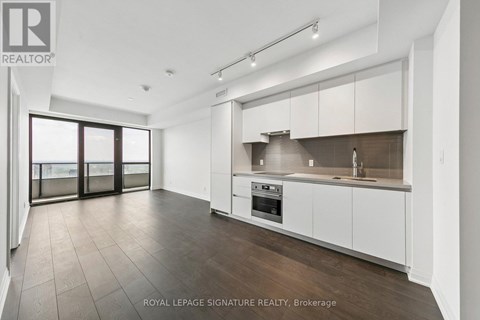 A spacious kitchen with white cabinets and a dark countertop.