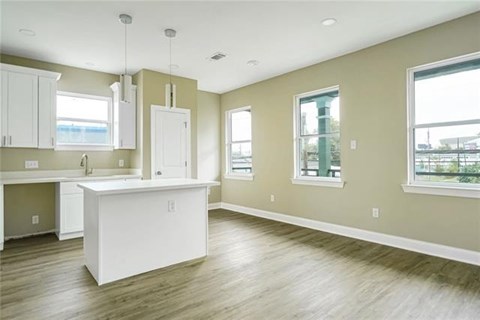 A kitchen with a white island in the middle of the room.