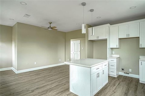 A kitchen with white cabinets and a ceiling fan.