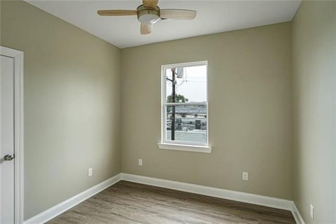 A room with a window and a ceiling fan.