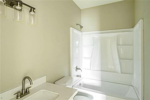 A white bathroom with a sink and a shower.