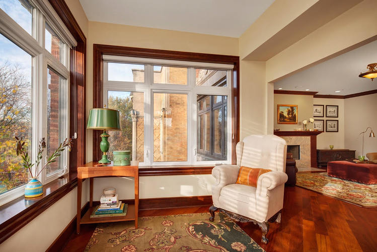 A living room with a white chair and a green lamp.