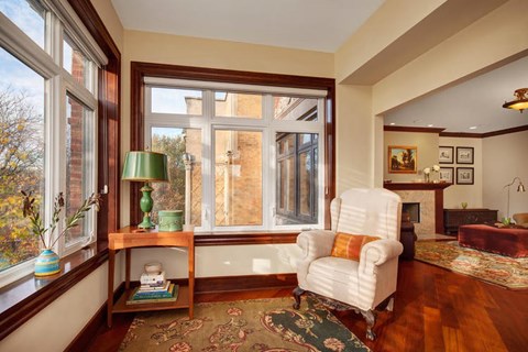 A living room with a white chair and a green lamp.