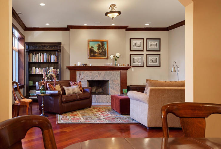A living room with a fireplace and a painting above it.
