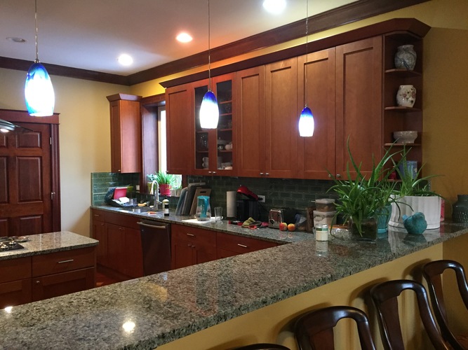 A kitchen with brown cabinets and a granite countertop.