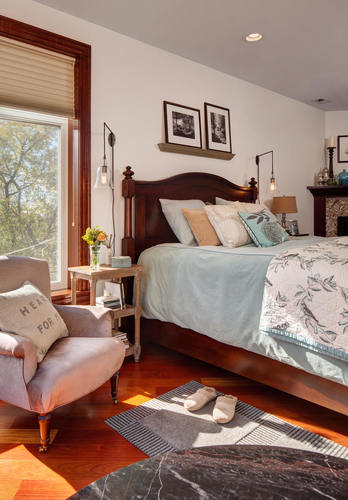 A bedroom with a large bed and a chair with a pillow that says "Here for".