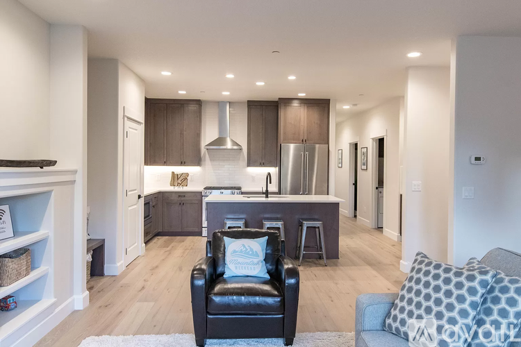 A modern kitchen with a black leather chair in the middle of the room.