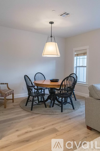 A dining room with a wooden table and chairs.