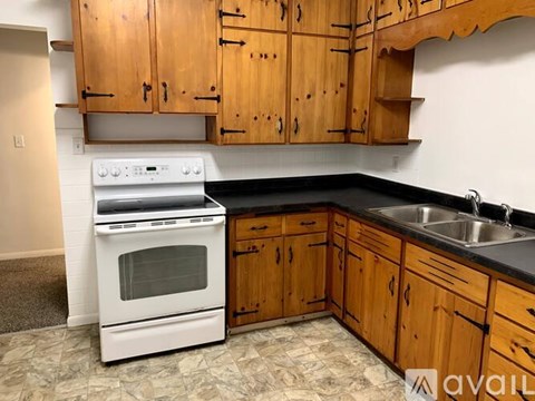A kitchen with wooden cabinets and a white oven.