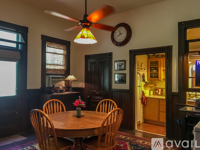 A dining room with a wooden table and chairs.