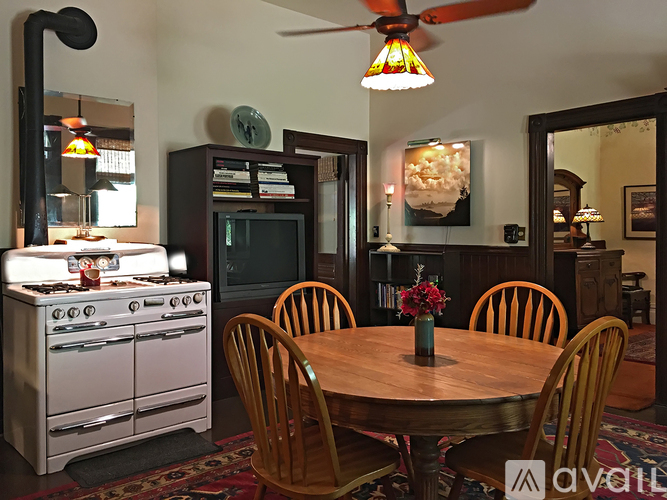 A kitchen with a stove, oven, and a table with chairs.