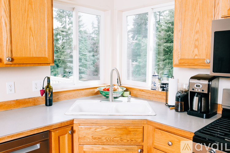 A kitchen with wooden cabinets and a white sink.