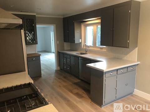 A kitchen with a stove top oven and cabinets.