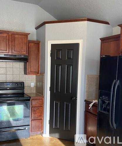 A kitchen with a black door and a black oven.