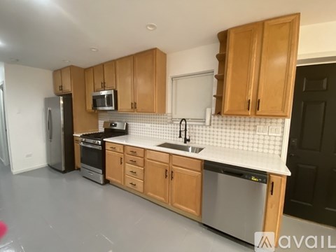 A kitchen with wooden cabinets and a white backsplash.