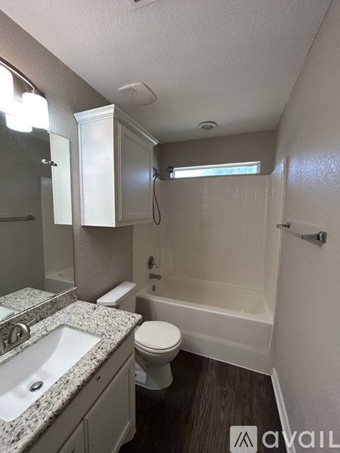 A bathroom with a sink, toilet and bathtub.