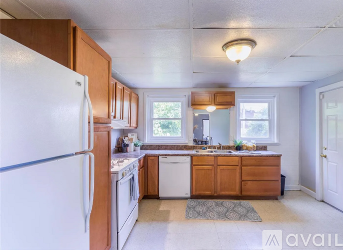 A kitchen with white appliances and wooden cabinets.