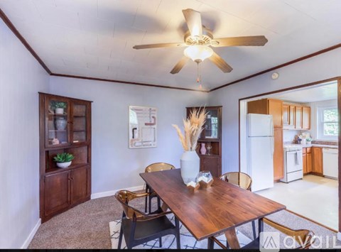 A dining room with a wooden table and chairs.